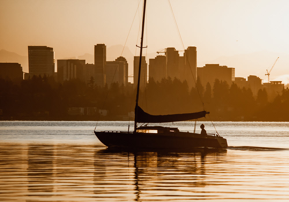 Fishing boat at sunset with Bellevue, Washington skyline in the background.