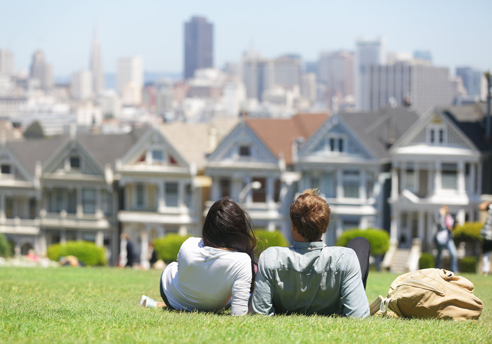Couple at the Alamo Square Park looking at the Painted ladies in San Francisco, California.