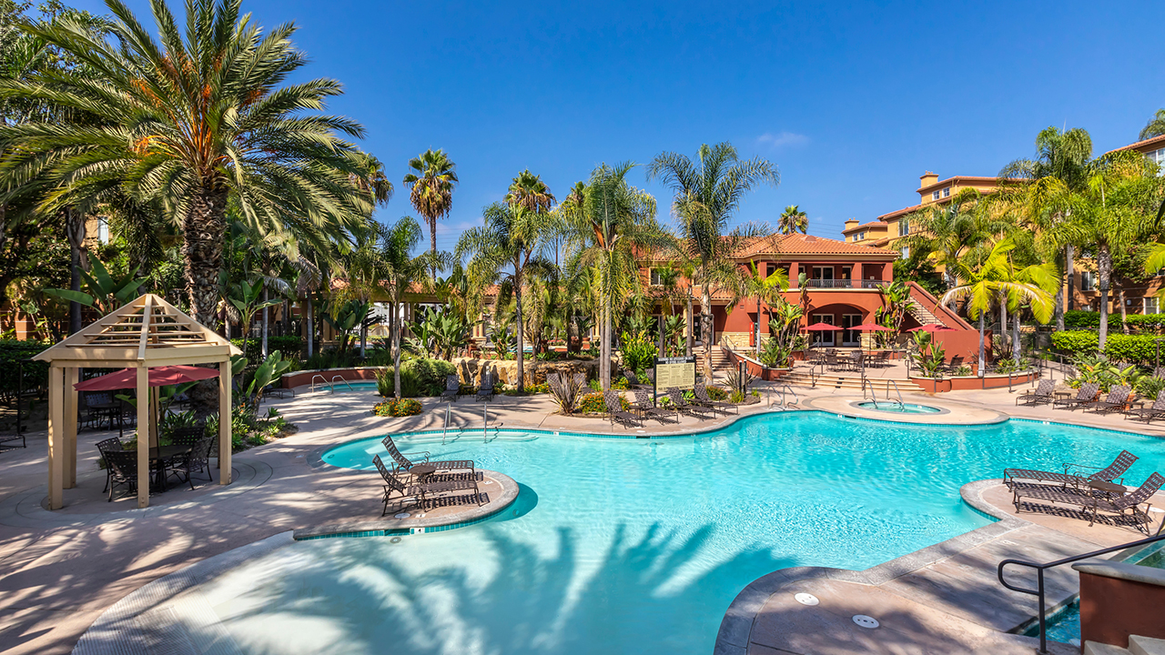 Poolside Paradise featuring lush surroundings, lounge seating, and cabanas