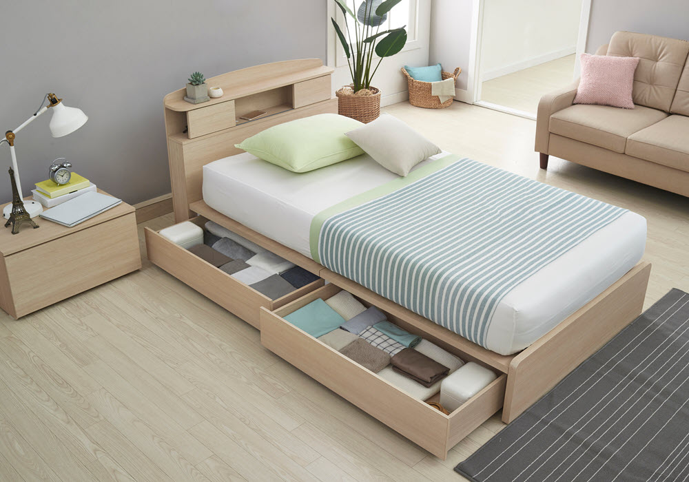 A staged bed with storage drawers in an apartment room.
