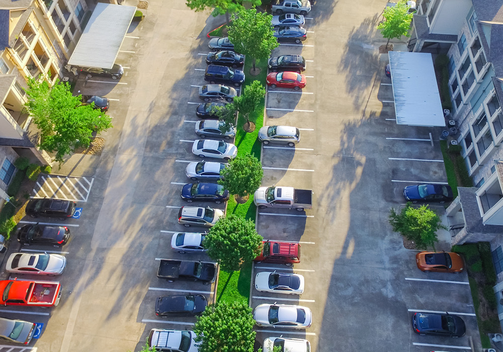 Overview of parking lot filled with cars.