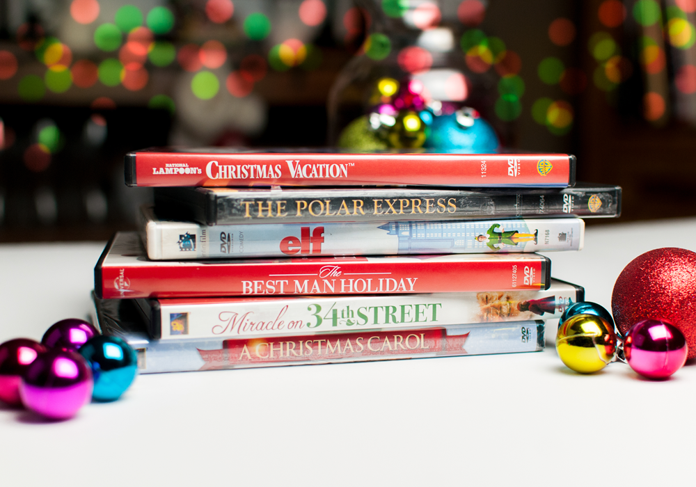 A stack of 6 holiday DVDs with ornaments on the side.