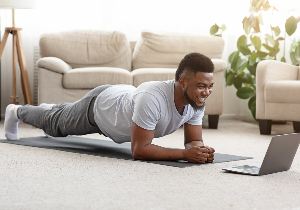 Man in a plank form in his apartment home.