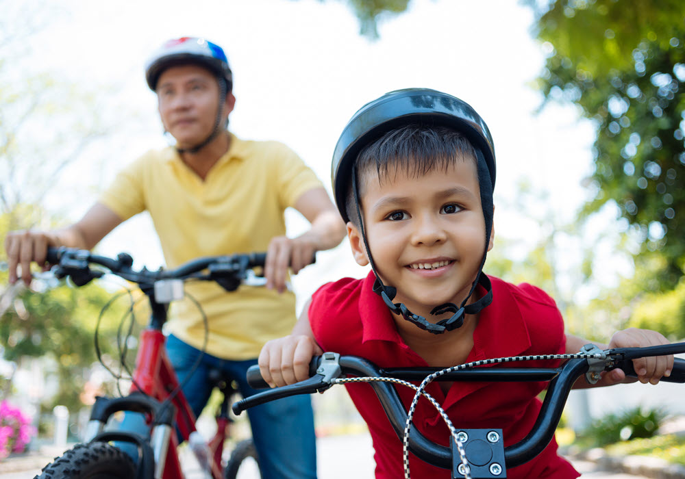 Boy and father on a bike ride together.
